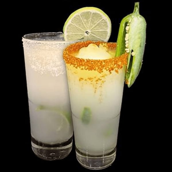 Two frosty margaritas, one with a lime slice and the other with a chili-salt rim and jalapeño.