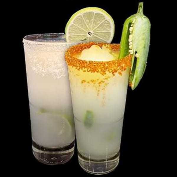 Two frosty margaritas, one with a lime slice and the other with a chili pepper and spiced rim.